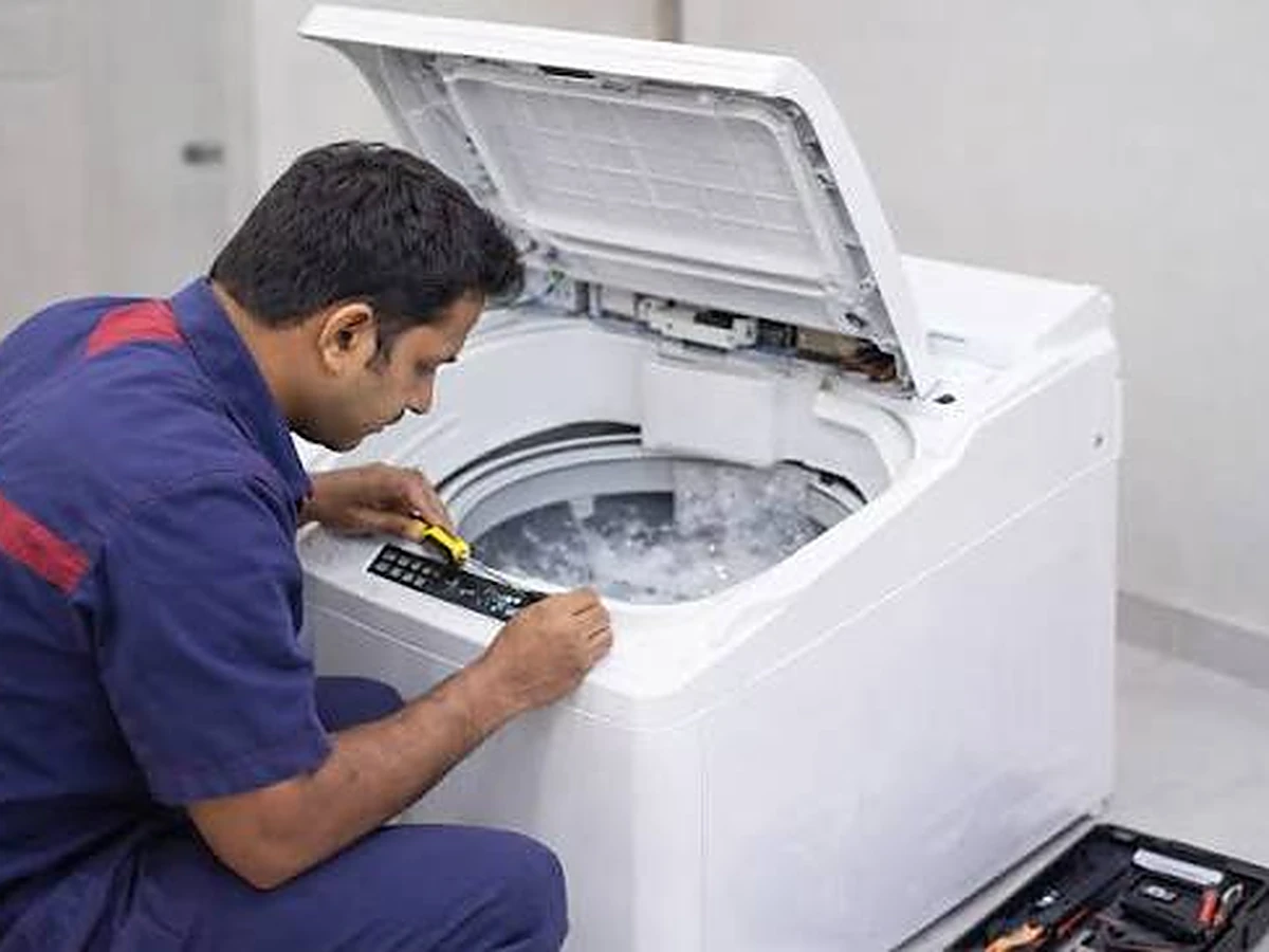 Technician checking the drum bearings of an IFB front load washing machine